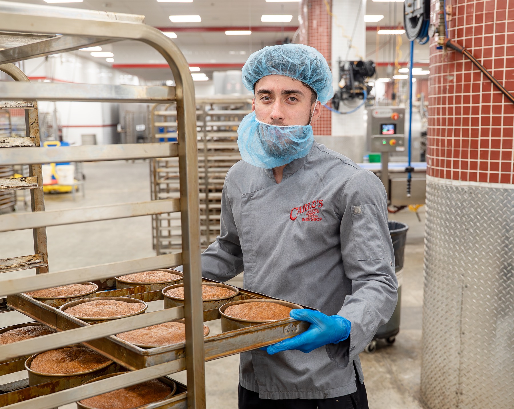 Carlo's Bakery baker moving fresh cakes