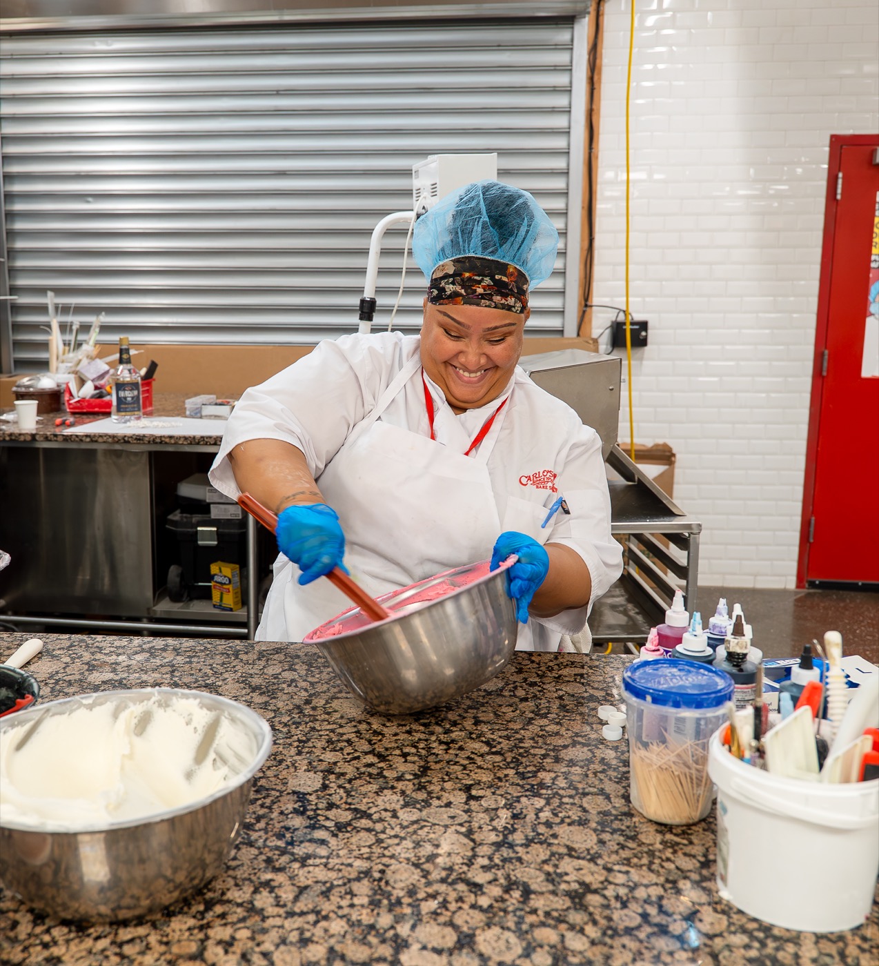 Carlo's Bakery team member mixing icing