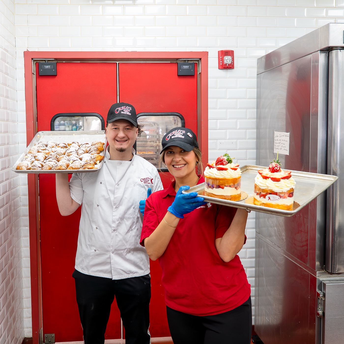 Carlo's Bakery team members presenting fresh pastries